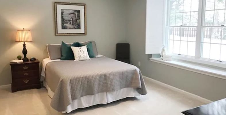 Well-decorated private resident room with a bed and artwork