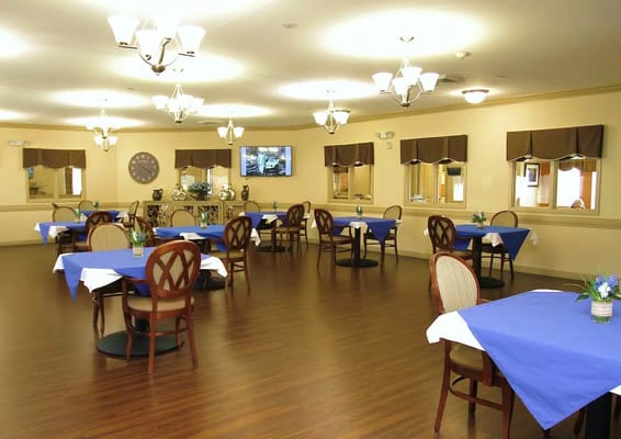 Bright dining room with blue tablecloths and wooden chairs