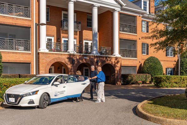 Residents and staff interacting near the facility entrance