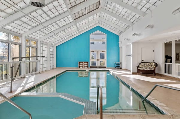 Indoor swimming pool area with a bright blue accent wall
