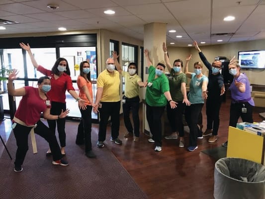 Staff members posing cheerfully in a common area