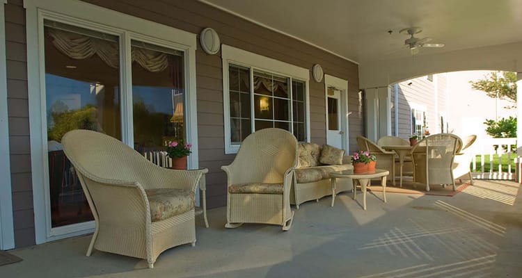 Outdoor seating area with wicker chairs and flower pots