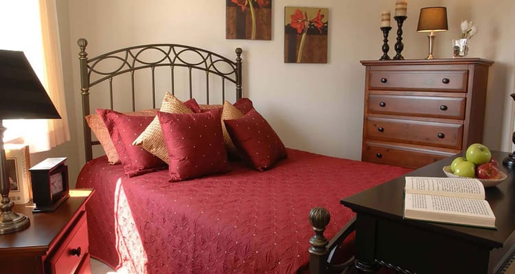 Cozy bedroom with red bedding and decorative pillows