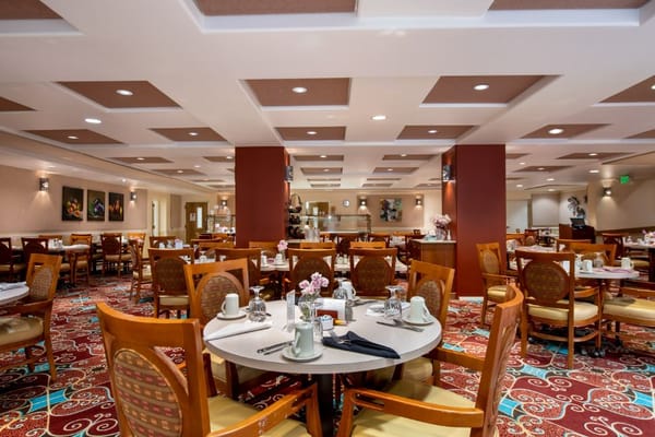 Dining area with tables and chairs at El Castillo senior living facility.