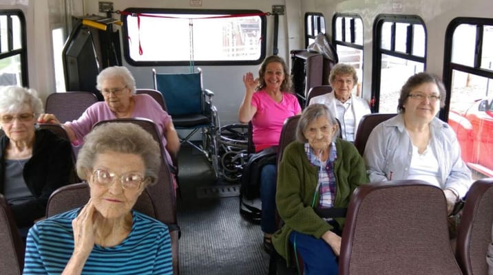 Group of senior residents on a bus, smiling and chatting