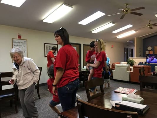 Residents and staff engage in activities in the common area.