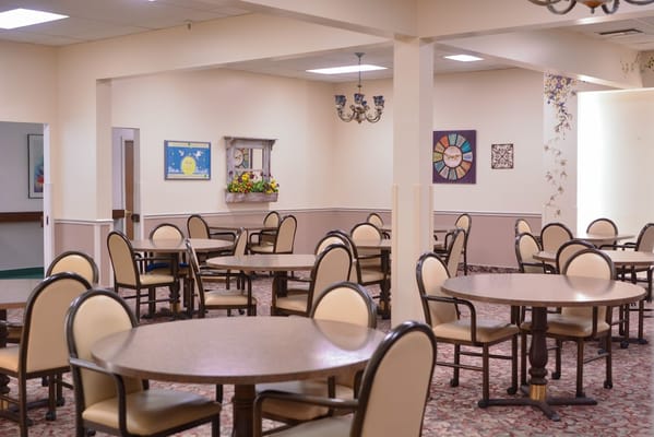 Empty dining area with tables and chairs at Gardens Assisted Living