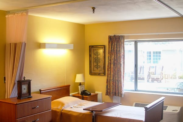 Cozy resident room with bedside table and window