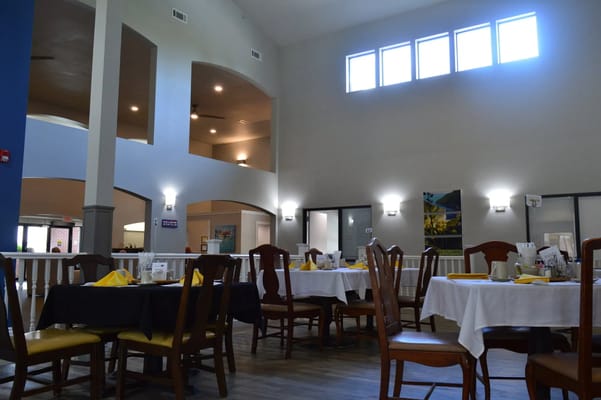 Well-lit dining area with tables set for meals