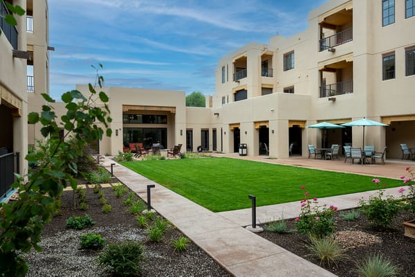 Outdoor courtyard with comfortable seating and green lawn