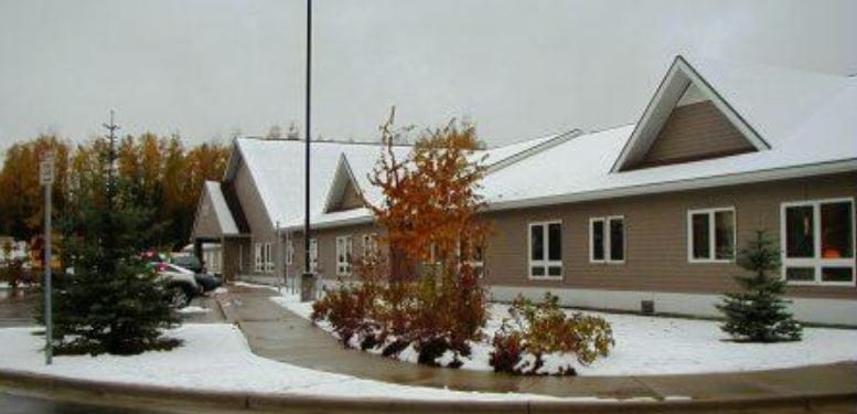 Exterior view of Sutton Manor with snow and autumn foliage