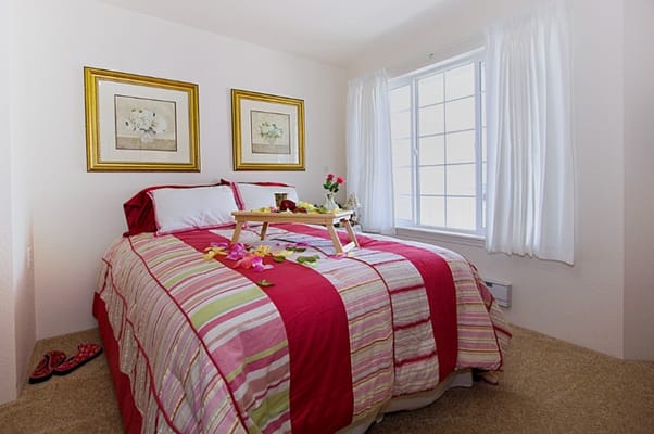 A beautifully arranged bedroom with striped bedding and floral artwork