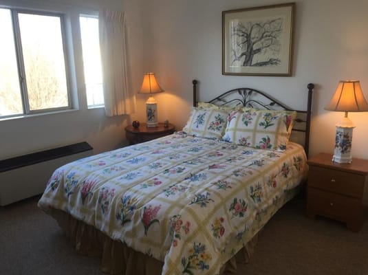 A well-decorated bedroom with floral bedding and lamps