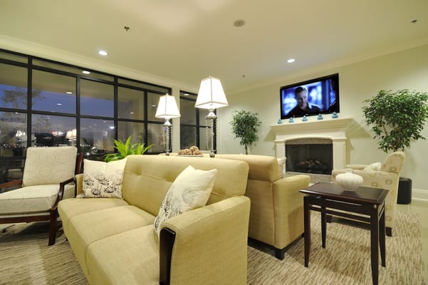 Common area with seating and a fireplace in a senior living facility