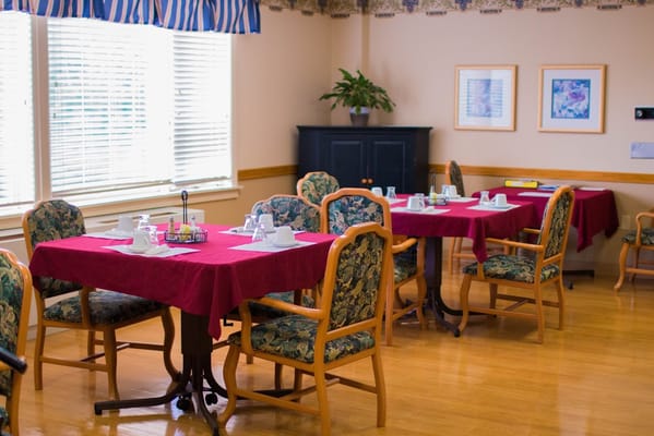 Dining area with red tablecloths and floral chairs