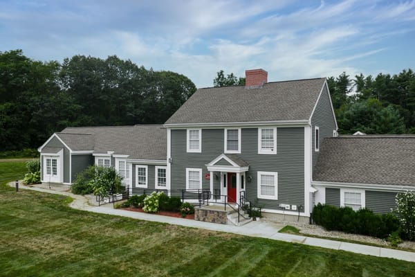 Exterior view of Johnson Creek Village showing the main entrance and landscaped surroundings.