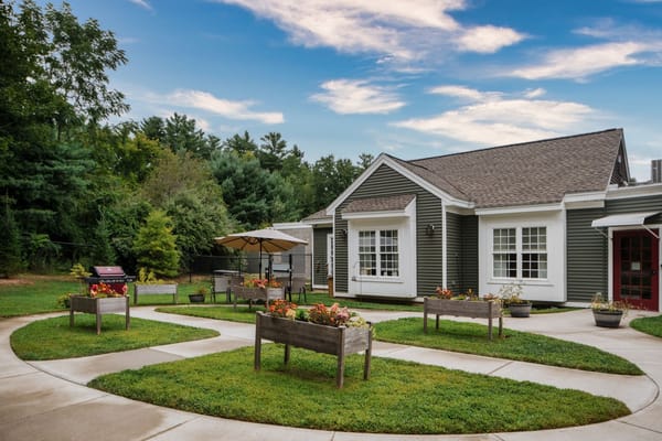 Beautifully landscaped outdoor area with flower boxes and a shaded seating area.