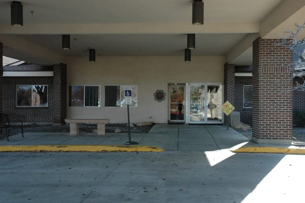 Entrance of a senior living facility with outdoor seating