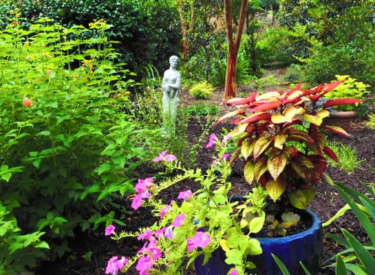 Beautiful garden with colorful plants and a statue