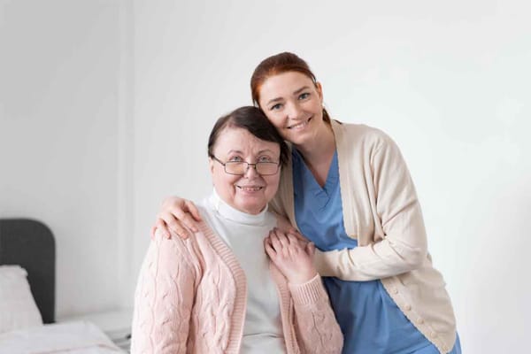 Caregiver smiling with a resident in a facility room
