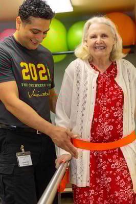 A staff member assisting a resident in a bright activity room