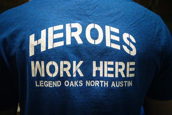 Staff member wearing a shirt with 'Heroes Work Here'