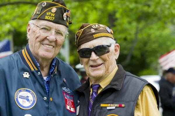 Two veterans smiling at an outdoor event