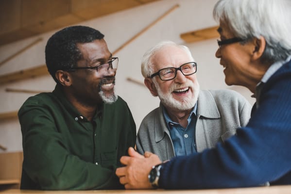 Three seniors enjoying a friendly conversation in a common area