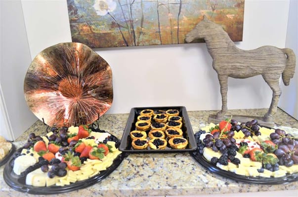 A beautifully arranged cheese and fruit platter in a common area