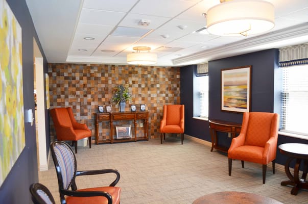 Cozy lounge area with orange chairs and decorative wall