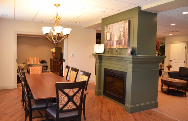 Bright common area with dining table and fireplace