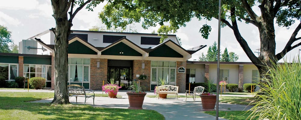 Exterior view of Holt Senior Care & Rehab Center with gardens