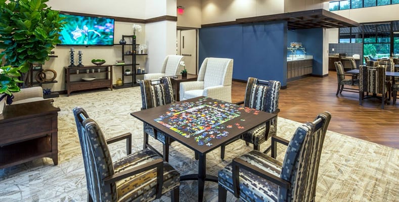 Bright activity room with residents engaged in puzzles