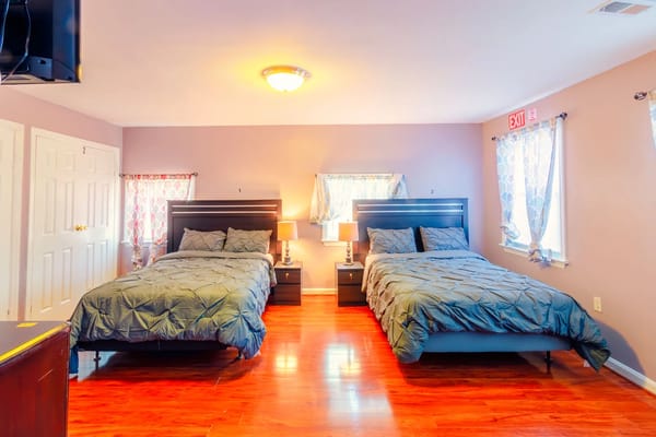 A furnished resident room with two beds and modern decor