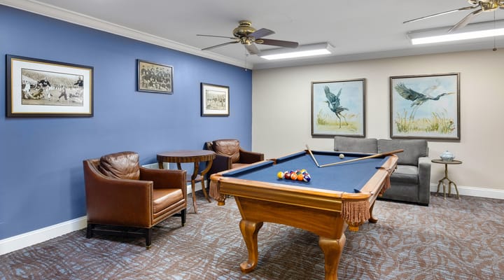 Interior game room with a pool table and seating