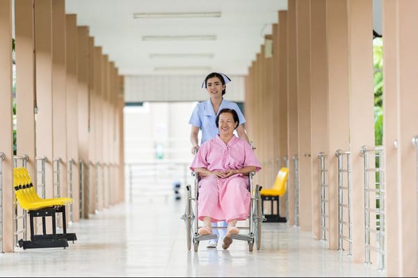 A nurse helping a resident in a hallway