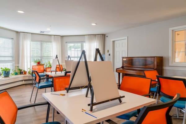 Bright interior art activity room with easels and chairs