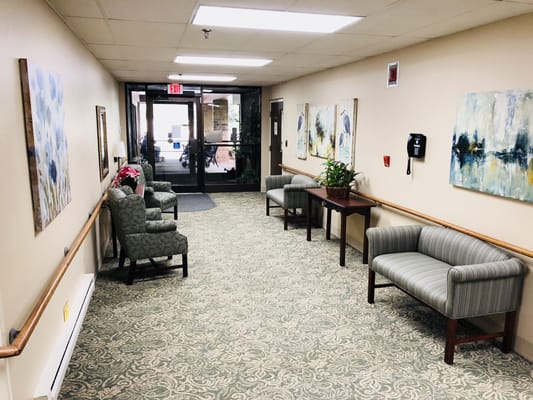 Hallway with seating and artwork in a senior living facility