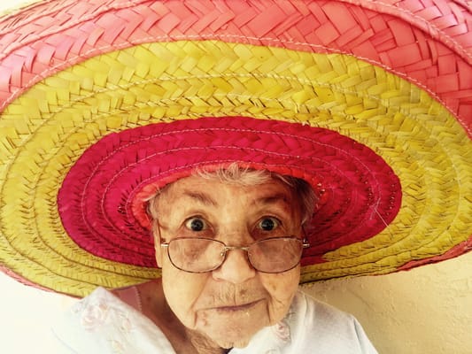 An elderly woman wearing a large colorful sombrero.