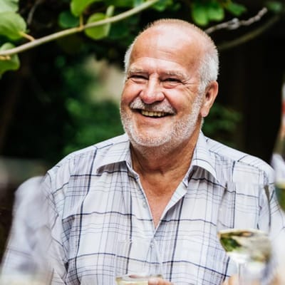Smiling older man enjoying a drink outdoors