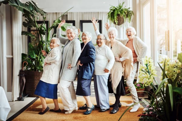 Group of smiling elderly women posing in a common area