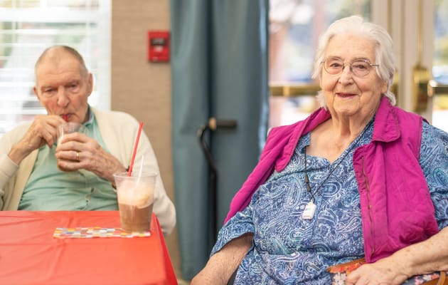 Two residents enjoying drinks in a common area