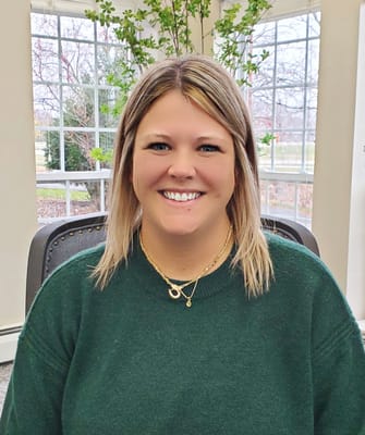 Staff member smiling in a well-lit common area