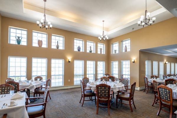 Dining area with tables set for meals and large windows