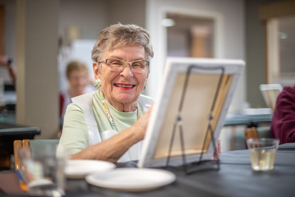 Senior resident painting at a social activity event