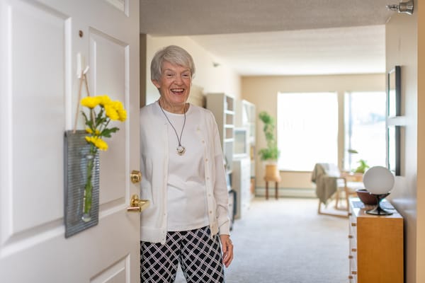 A smiling resident in a bright living space.