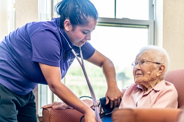 Nurse checking vitals of a senior resident indoors