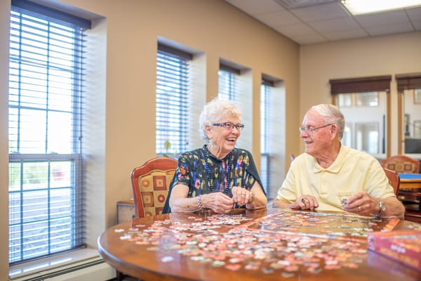 Two residents enjoying a puzzle together in an activity area
