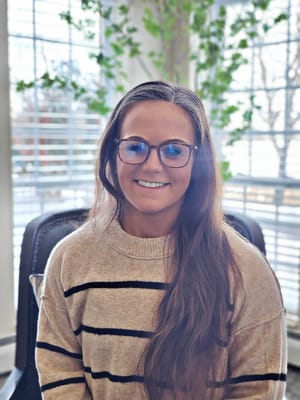 A staff member smiling in a bright common area