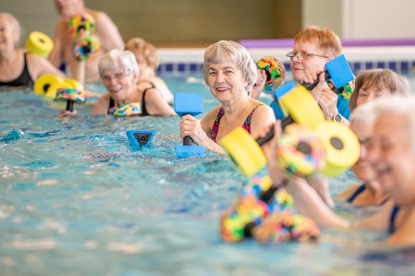 Residents participating in a lively water aerobics class